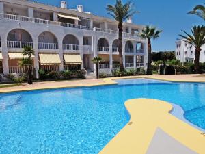 uma grande piscina em frente a um edifício em RODERIC - Apartamento junto al Mar em Oliva
