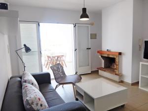 uma sala de estar com um sofá, uma mesa e uma lareira em RODERIC - Apartamento junto al Mar em Oliva