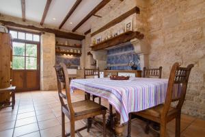 a kitchen with a table and chairs in a room at Belle maison de maître - Piscine et jardin privés - Au cœur du village médiéval de Caylus - 4 personnes - Garage in Caylus