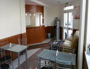 ein Wohnzimmer mit 2 Tischen und einem Sofa in der Unterkunft Hotel des Bains in Maisons-Alfort