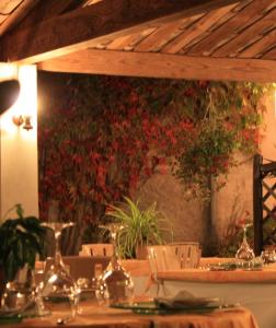 un comedor con mesas, sillas y flores rojas en Les Norias, en Cazilhac