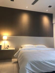 a bedroom with a large white bed with a black wall at Setia Walk Puchong in Puchong