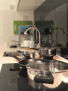 two pots and pans on a stove in a kitchen at Setia Walk Puchong in Puchong