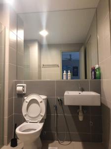 ein Badezimmer mit einem WC, einem Waschbecken und einem Spiegel in der Unterkunft Setia Walk Puchong in Puchong
