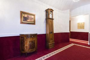 una habitación con un reloj de abuelo en la pared en Phi Hotel Principe, en Cuneo