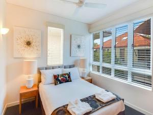 een slaapkamer met een bed, 2 lampen en een raam bij Laguna on Hastings in Noosa Heads