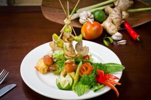 a plate of food with vegetables on a table at Sri Phala Resort & Villa in Sanur