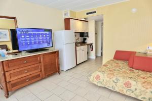 a living room with a television and a kitchen at Quebec Motel in Wildwood
