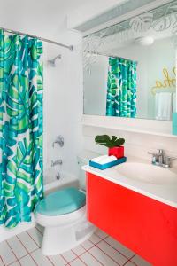 a bathroom with a toilet and a sink at Shoreline Hotel Waikiki in Honolulu