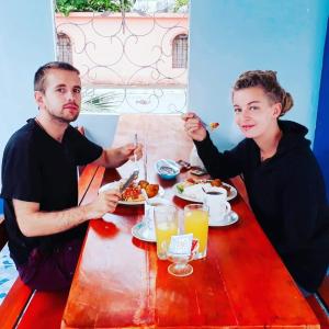 a man and woman sitting at a table eating food at Hostal Aruba in Atacames