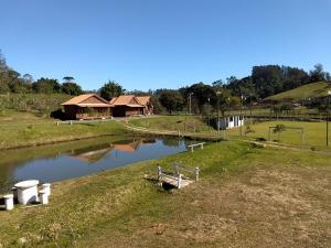 ein kleiner Teich auf einem Feld neben einem Haus in der Unterkunft Sitio Esperanca in Lauro Müller