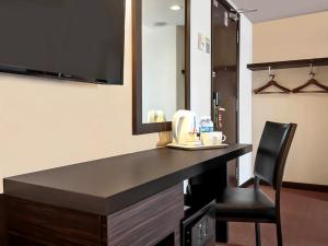 a desk in a room with a mirror and a chair at Hotel Summer View in Kuala Lumpur