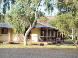 a building with a tree in front of it at Heritage Caravan Park in Alice Springs