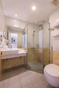 ein Bad mit einer Dusche, einem Waschbecken und einem WC in der Unterkunft Splendid Hotel & Spa in Hanoi