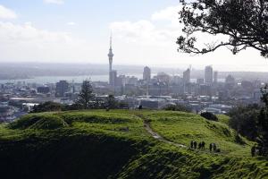 einen Blick auf die Skyline des ucksvollen Landes von der Spitze eines grasbewachsenen Hügels mit in der Unterkunft The Grange in Auckland