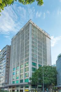 un grand bâtiment blanc avec des arbres devant lui dans l'établissement Silka Far East Hotel, à Hong Kong