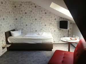 a bedroom with a bed and a table with a tv at Pension Klabautermann in Stralsund