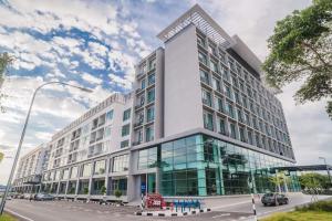 a large white building with glass windows on a street at C Residence Labuan in Labuan