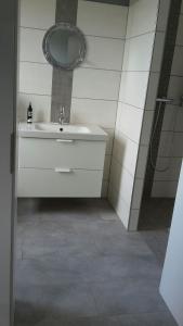 ein Bad mit einem Waschbecken und einem Spiegel in der Unterkunft Landidylle in Bremke