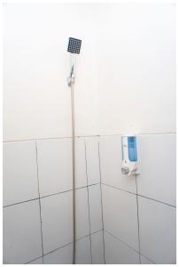 einem Duschkopf an der Seite einer weißen Wand in der Unterkunft Budi House & Food Station in Bandung + 37 Fotos