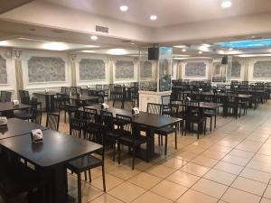 uma sala de jantar cheia de mesas e cadeiras em Lech Hotel em Luodong