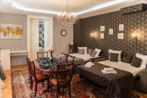 una habitación con dos camas y una mesa con sillas en Weidner Apartments, en Sibiu