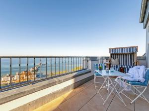einen Balkon mit einem Tisch, Stühlen und Meerblick in der Unterkunft FIRST Sellin - Meerblick-Suite "View" in Ostseebad Sellin