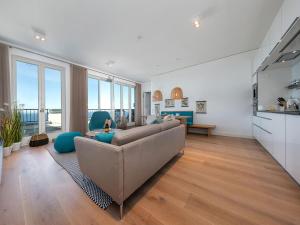 a living room with a large couch and a living room with windows at FIRST Sellin - Meerblick-Suite "View" in Ostseebad Sellin
