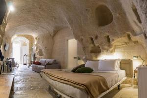 een slaapkamer met een groot bed in een stenen muur bij Thymus Residence nei Sassi in Matera