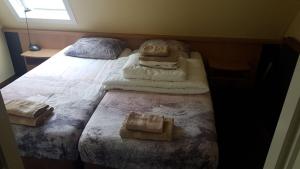 een slaapkamer met een bed met handdoeken erop bij Appartement Senang, Resort Amelander Kaap in Hollum