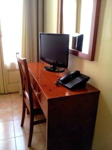 a desk with a computer and a telephone on it at Hotel Toledano Ramblas in Barcelona