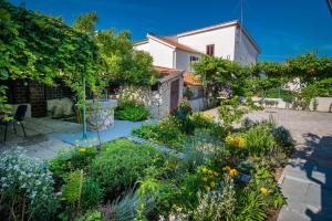 a garden in front of a house with flowers at Apartment Sandra Krk in Krk
