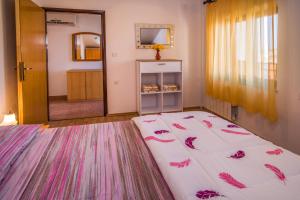 a bedroom with a large bed with pink flowers on it at Apartment Sandra Krk in Krk