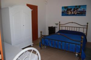ポリコーロにあるDa stefanoのベッドルーム(青いベッド1台、白いキャビネット付)
