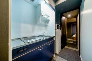 cocina azul con fregadero y nevera en RESI STAY Tsubaki, en Kioto