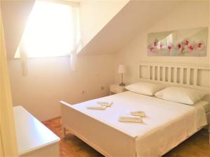 a bedroom with a white bed with towels on it at Apartments Mija in Bol