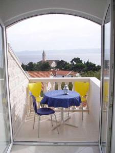 einen Tisch und Stühle auf einem Balkon mit Aussicht in der Unterkunft Apartments Mija in Bol