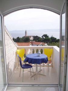 una mesa y sillas en un balcón con vistas en Apartments Mija, en Bol