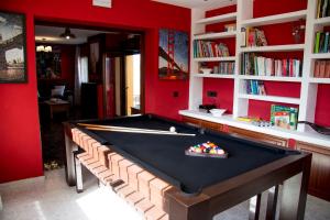 a pool table in a room with red walls at Casa Rural Collarubio in Collado Mediano