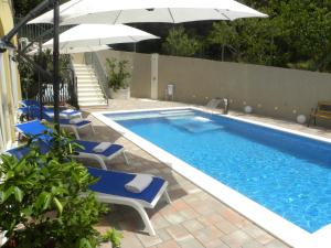 a swimming pool with blue chairs and an umbrella at Anka Strman in Makarska
