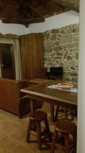 uma sala de jantar com uma mesa de madeira e bancos em Apartamento do Xurés em Maus de Salas