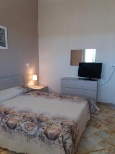 カザラーノにあるLA PERGOLA OSPITALITA'のベッドルーム(ベッド1台、薄型テレビ付)