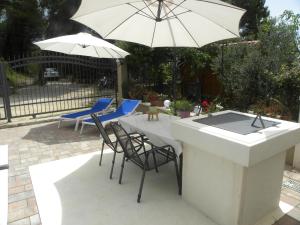 een tafel met stoelen en een parasol op een patio bij Anka Strman in Makarska