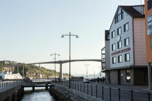 a building next to a river with a bridge in the background at Thon PartnerHotel Storgata in Kristiansund