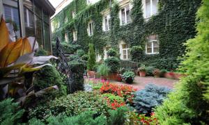 a garden in front of a building with plants at Stikliai Palace Residence in Vilnius