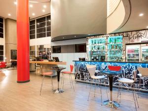 a restaurant with colorful chairs and tables and a bar at ibis Campinas in Campinas