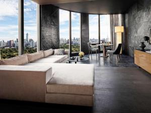 a living room with a couch and a view of the city at SO/ Bangkok in Bangkok
