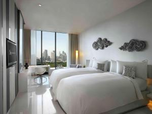 a hotel room with two beds and a large window at SO/ Bangkok in Bangkok