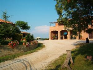 uma casa com uma entrada de cascalho em frente em Agriturismo Marruchetone Vecchio em Marsiliana