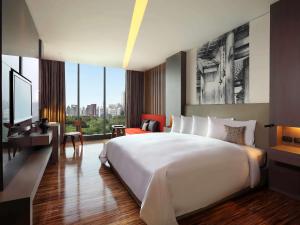 a hotel room with a large bed and a television at SO/ Bangkok in Bangkok